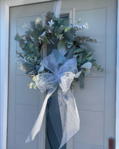 Silver themed Christmas wreath on a grey front door 