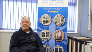 Team member seated beside a poster showing different window styles inside the showroom